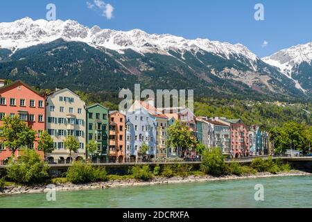 INNSBRUCK, AUTRICHE - 5 MAI 2016 : les célèbres maisons colorées le long de la rivière Inn à Innsbruck, Autriche. Les sommets enneigés des Alpes sont moi Banque D'Images