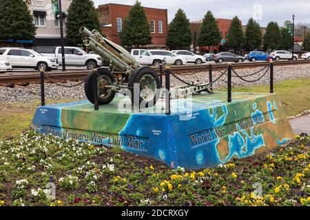 KINGS MTN, NC, USA-4 MARS 2020: Un canon commémorant les guerres dans le passé des Etats-Unis, entouré d'un lit de fleurs. Banque D'Images