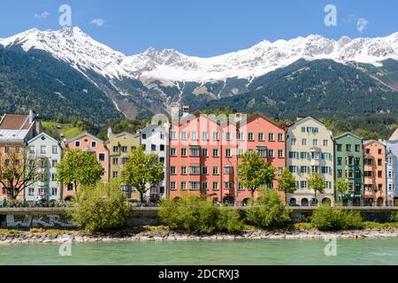 INNSBRUCK, AUTRICHE - 5 MAI 2016 : les célèbres maisons colorées le long de la rivière Inn à Innsbruck, Autriche. Les sommets enneigés des Alpes sont moi Banque D'Images