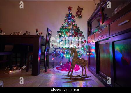 Décoration de Noël dans la salle de grunge intérieur, chaise pour enfants à bascule cheval, arbre du nouvel an classique Banque D'Images