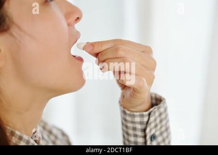 Woman taking tablet Banque D'Images
