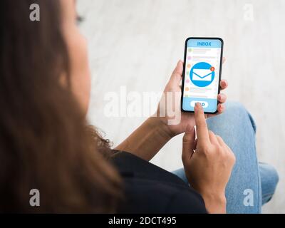 Marketing par e-mail. Femme méconnaissable recevant une nouvelle notification par courrier électronique sur son téléphone portable, vue rognée Banque D'Images