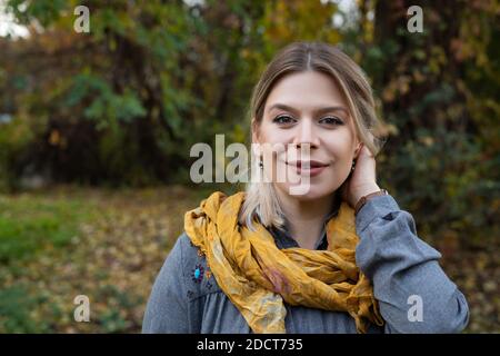 Portrait d'une jeune belle femme caucasienne souriant à la caméra extérieure dans une scène automnale Banque D'Images