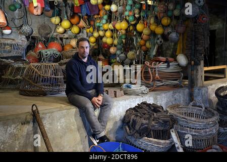 Angleterre / Cornwall / St. Ives / l'artiste Sam Bassett posant dans la cave sous les studios d'artistes où les pêcheurs fixent des filets sur la plage de Porthmeor. Banque D'Images