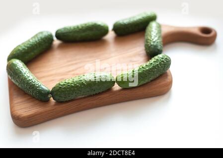 Mise en page créative de concombres de légumes frais sur panneau en bois blanc Banque D'Images