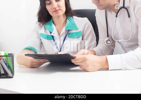 Deux médecins, un homme et une fille, se confient à la clinique pour établir un diagnostic. Concept de formation des étudiants en médecine, développement du personnel Banque D'Images