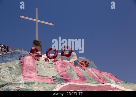 Vue générale du mont du Salut à Niland, CA, États-Unis en 2017. L'œuvre est faite d'adobe, de paille et de milliers de gallons de peinture sans plomb. La montagne du salut a été créée par le résident local Leonard Knight (1931–2014). Elle englobe de nombreuses peintures murales et des zones peintes avec des paroles chrétiennes et des versets bibliques, bien que sa philosophie ait été construite autour de la prière du pécheur. La Folk Art Society of America l'a déclaré « site d'art populaire digne de préservation et de protection » en l'an 2000. Dans un discours devant le Congrès américain le 15 mai 2002, la sénatrice de Californie Barbara Boxer l'a décrit comme « unique » Banque D'Images