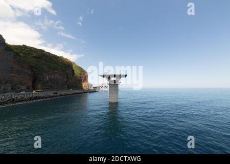 PAS DE WEB/PAS D'APPLICATIONS - EXCLUSIF. Vue générale du chantier de la nouvelle route côtière (Nouvelle route du littoral) avec colonnes de viaduc et leurs voussoires (éléments en forme de coin) en haut, à la Réunion, France, en octobre 2017. La nouvelle route côtière de 12.3 km reliera Saint-Denis, la capitale administrative de l’île, à la possession et remplacera la route existante, qui sera sujette aux chutes de roches et aux inondations durant les tempêtes tropicales. Il aura trois voies dans chaque direction et améliorera le transport une fois terminé en 2018. Ce sera la route/km la plus chère financée en France avec Banque D'Images