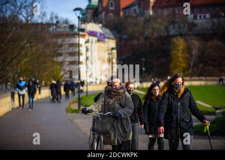 Les personnes portant des masques protecteurs contre la propagation du covid 19, alors qu'elles marchent sur la place principale inscrite au patrimoine mondial de l'UNESCO à Cracovie. Banque D'Images