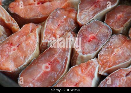 Des tranches de poisson rouge sont disposées en rangée. Résumé du saumon kéta ou saumon rose en gros plan. Toile de fond pour les produits du poisson Banque D'Images