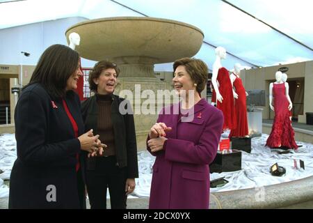 La première dame Laura Bush partage un moment de lumière avec Fern Malles de la 7e sur la Sixième, à gauche, et Lynn long, chef de la production de la semaine de la mode, après avoir passé en revue les robes de designer exposées pour « The Red Dress Project » à Bryant Park à New York le vendredi 14 février 2003. « le projet de robe rouge » fait partie de la campagne de vérité cardiaque pour sensibiliser les femmes à la maladie cardiaque comme la première tueuse. Les robes ont été créées par 19 designers américains et voyageront pendant un an, puis seront mises aux enchères au profit de l'American Heart Association. Crédit obligatoire : Susan Sterner / Maison Blanche via CNP/ABACA Banque D'Images