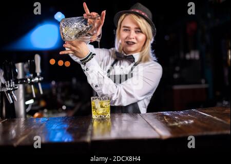 Un barman concocte un cocktail derrière le bar Banque D'Images