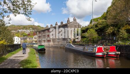 Des bateaux amarrés à côté d'une belle terrasse de cottages au bord du canal Sur le canal Rochdale au pont Hebden dans le West Yorkshire Banque D'Images