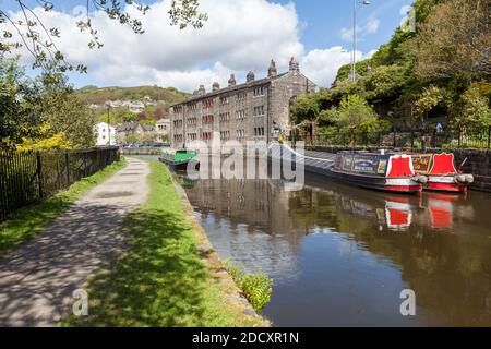 Des bateaux amarrés à côté d'une belle terrasse de cottages au bord du canal Sur le canal Rochdale au pont Hebden dans le West Yorkshire Banque D'Images