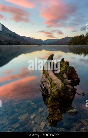 Magnifique lever de soleil rose avec des reflets calmes à Ullswater, dans le Lake District. Banque D'Images