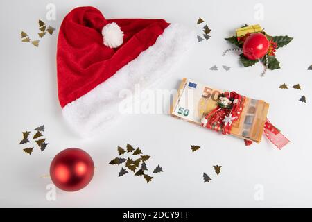 Chapeau de père Noël et billets en euros sur fond blanc Banque D'Images