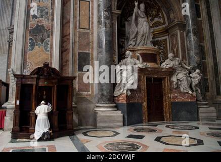 Le pape François s’agenouille en confession après la célébration d’une célébration pénitence à la basilique Saint-Pierre au Vatican, le 9 mars 2018. A droite : la tombe du pape Benoît XIV Le service de pénitence à la basilique Saint-Pierre a marqué le début de la célébration mondiale de ‘24 heures pour le Seigneur’, une période où au moins une église de chaque diocèse a été invitée à être ouverte toute la nuit pour la confession et l’adoration eucharistique. Après avoir donné son homélie au service, le Pape François a marché jusqu'à l'un des confessionels de la basilique et s'est épeillé devant un prêtre pour confesser ses péchés. Puis il est allé à un Banque D'Images