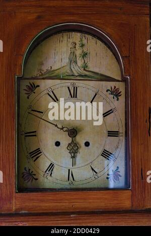 Ancienne horloge maison avec des chiffres noirs classiques sur le cadran blanc fissuré et orné et des flèches métalliques. Banque D'Images