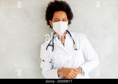 Les femmes afro-américaines portent un uniforme blanc et un visage protecteur masque dans l'hôpital Banque D'Images