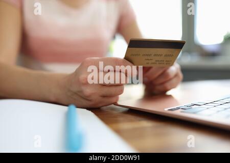 La femme tient une carte de crédit en plastique et effectue des achats en ligne Banque D'Images