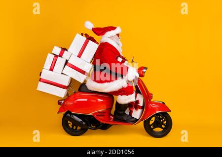 Profil vue de côté de son il Nice drôle FAT St Nicholas Driving Motor bike hâte de livrer pile de cadeaux Eve Noel tradition d'hiver isolée Banque D'Images