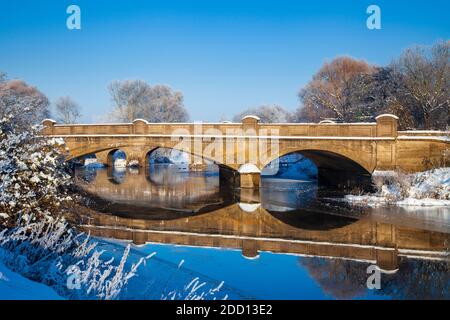 Les arches des ponts nouveaux et anciens de Pershore couvertes de neige et se reflétant dans la rivière gelée Avon, Worcestershire, Angleterre Banque D'Images