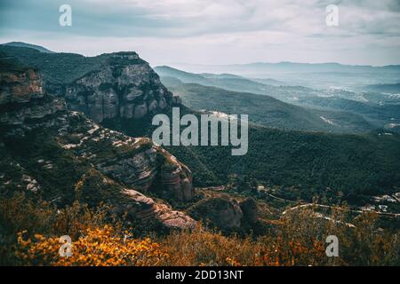 Un paysage imposant de montagnes et de champs accidentés qui s'étendent À l'horizon à Sant Miquel del Fai Banque D'Images