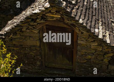 Un gros plan en grand angle d'une hutte rustique en pierre brute dans un village Banque D'Images