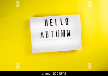 Bonjour automne texte sur la visionneuse sur fond jaune isolé vue du dessus, plat Banque D'Images