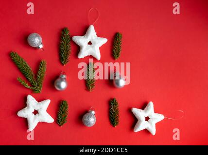 Composition du nouvel an. Décorations de Noël, cônes et branches de sapin sur fond rouge avec espace pour le texte. Mise en page d'une carte postale. Banque D'Images