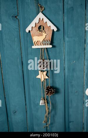 Studio décoratif de Noël avec une maison avec porte bleue, banc en bois et skis, bonhomme de neige, faux nuages et neige Banque D'Images