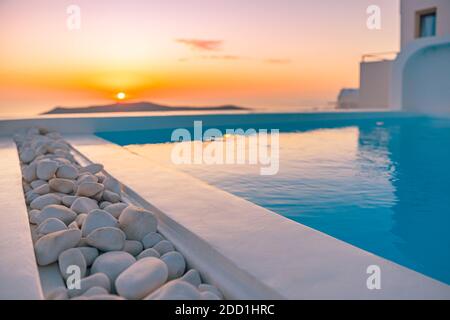 Coucher de soleil au bord de la piscine à Santorini, piscine à débordement avec vue sur l'océan caldera de Santorini. Un voyage d'été incroyable, tranquille Banque D'Images