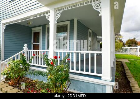 Une véranda enveloppante couverte sur une maison victorienne d'époque avec des rosiers à l'avant de Spokane, Washington, États-Unis Banque D'Images