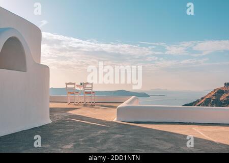 Restaurant en plein air au coucher du soleil, chaises pour couple. Vue romantique sur le coucher du soleil, ciel orange et nuages. Vacances d'été, voyage de lune de miel Banque D'Images