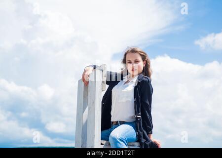 Elle est vraiment mignonne. Enfant mignon sur fond de ciel. Salon de coiffure. Look tendance décontracté. Belle jeune fille aux cheveux bouclés. Style de mode enfant. Beauté naturelle féminine. Enfance heureuse. Banque D'Images