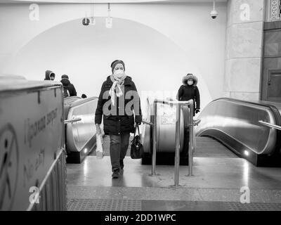 Moscou. Russie. 13 novembre 2020. Les passagers du métro prennent un escalier roulant depuis le métro. Sur les visages des personnes, masques médicaux de protection contre les virus Banque D'Images