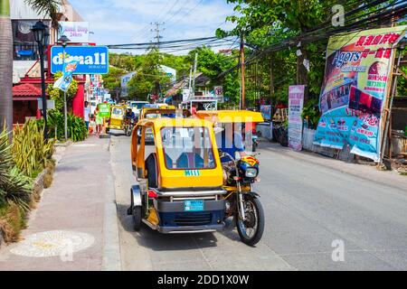 BORACAY, PHILIPPINES - 04 MARS 2013 : tricycle dans la rue principale de l'île de Boracay. Tricycle est un taxi public très populaire aux Philippines. Banque D'Images