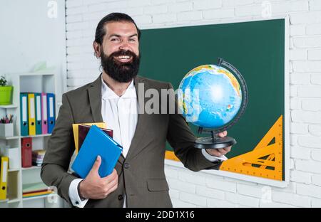 Portrait d'un enseignant d'école dans la classe académique avec globe, géographie. Banque D'Images