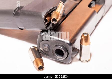 Un pistolet noir de 9 mm avec un magasin chargé de creux pointez les puces et deux autres puces sur un fond blanc Banque D'Images