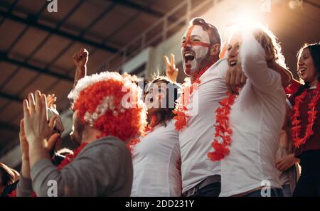 Des fans enthousiastes et des gens qui célèbrent la réussite de l'équipe. Groupe de fans de football d'Angleterre applaudissent dans les tribunes. Banque D'Images