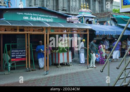 Madurai, Inde - 02 novembre 2018 : les dévotés faisant le rituel devant l'entrée d'un temple hindou, une boutique de fleurs est visible pour la vente en raison de sa r Banque D'Images