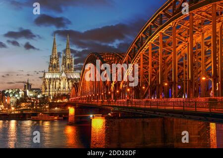 Coucher de soleil à Cologne (Köln) dans la région de Rhénanie du Nord Westphalie en Allemagne, surprenant la cathédrale de Cologne (Kolner Dom) et le pont Hohenzaller o Banque D'Images