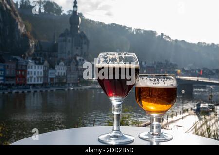 Boire de la bière d'abbaye belge sombre et forte avec des fromages par temps ensoleillé avec belle vue sur la rivière Maas et la ville de Dinant, Belgique Banque D'Images