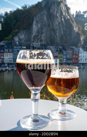 Boire de la bière d'abbaye belge sombre et forte avec des fromages par temps ensoleillé avec belle vue sur la rivière Maas et la ville de Dinant, Belgique Banque D'Images