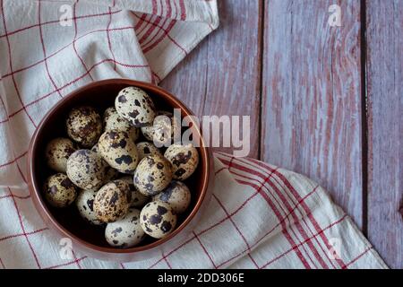 Des oeufs de cailles dans bol en bois sur fond de bois Banque D'Images