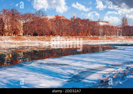 rive de la rivière en hiver. paysage urbain par une journée ensoleillée. réflexion sur l'eau Banque D'Images