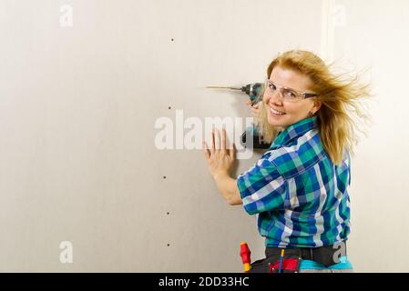 femme blonde avec un outil de tournevis dans les mains travaillant à la maison amélioration. concept des femmes de main Banque D'Images