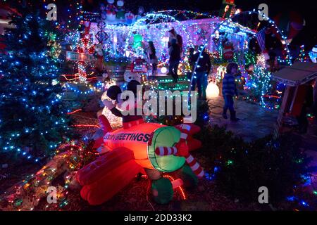 Les gens visitent une pelouse avant très décorée avec des lumières vives et colorées pendant la période des fêtes de Noël à Windsor, Californie, États-Unis. Banque D'Images