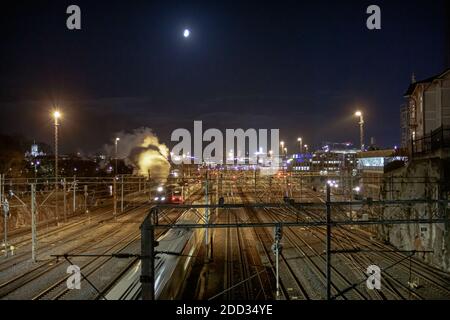 Photo nocturne d'une vieille locomotive à vapeur qui marche le long des voies ferrées. Photo de haute qualité Banque D'Images