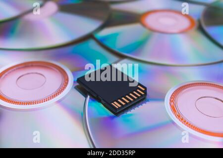 Stockage moderne des informations sur un lecteur flash par rapport aux anciens disques. Un lecteur flash moderne repose sur de vieux CD en gros plan Banque D'Images